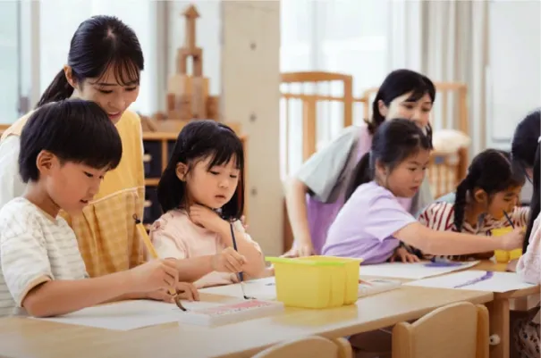 机を囲んで工作をする子どもたち